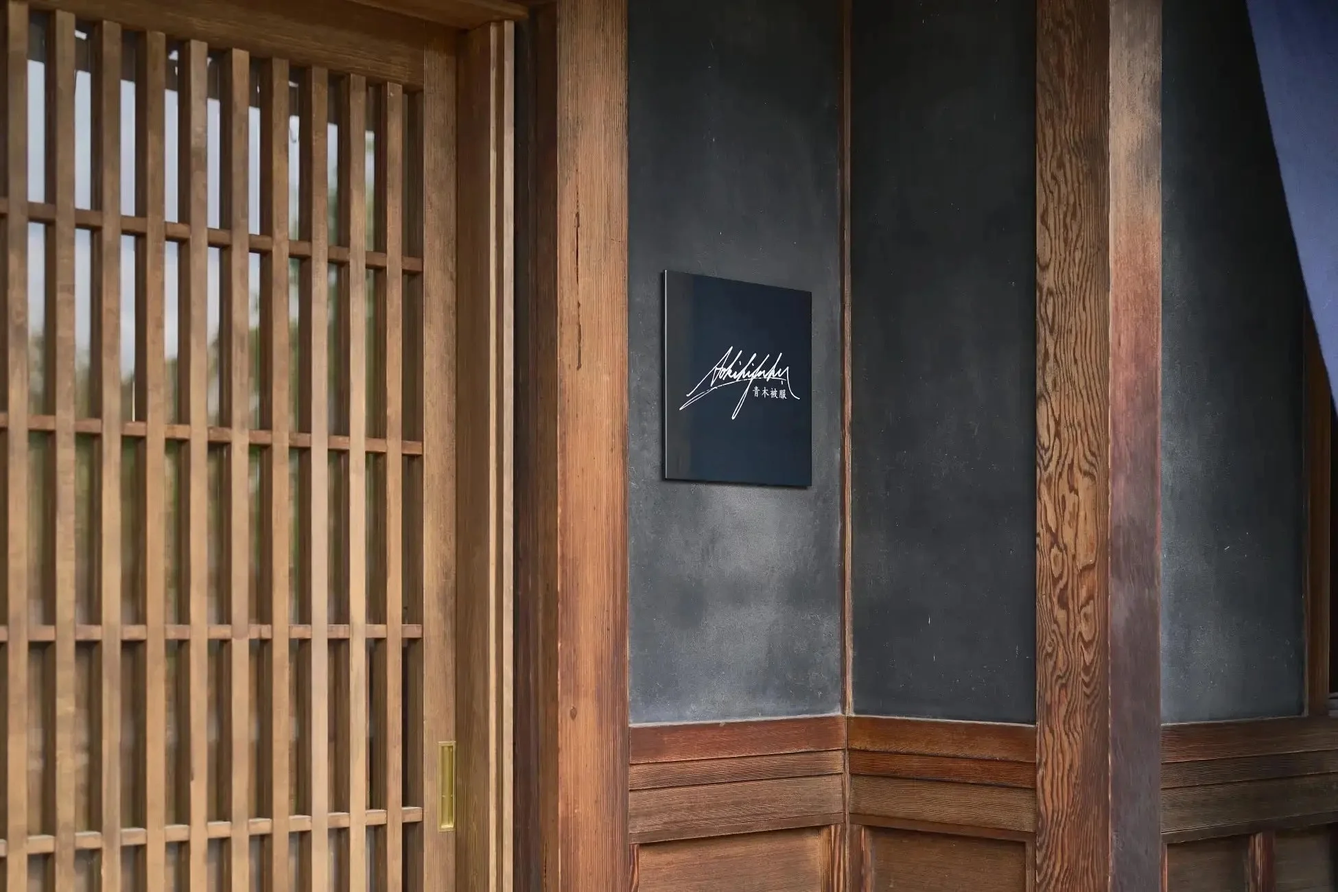 和風建築の入り口に「Akishino 青木被服」の看板