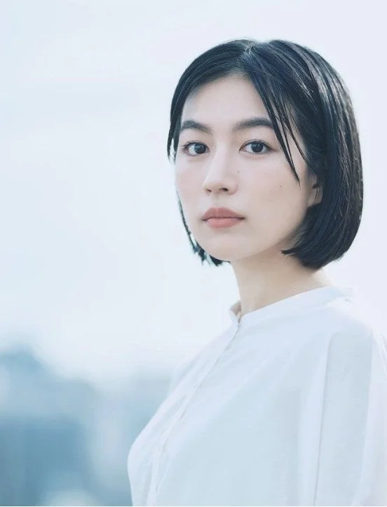 白いシャツを着たショートヘアの若いアジア人女性がカメラを見つめているポートレート写真