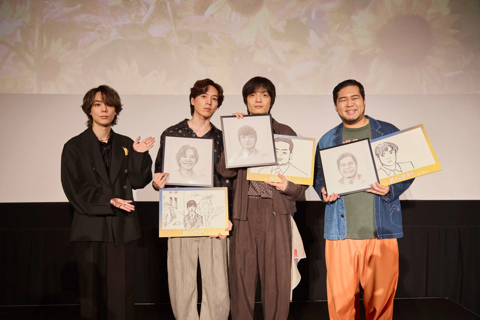 門脇監督が描いた似顔絵を手に集合した登壇者